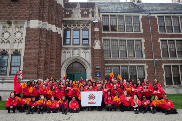 A ɫƵ AmeriCorps member school team posts for a group photo in front of a school.