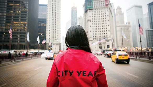ɫƵ AmeriCorp Member with their back towards the camera facing a large cityscape