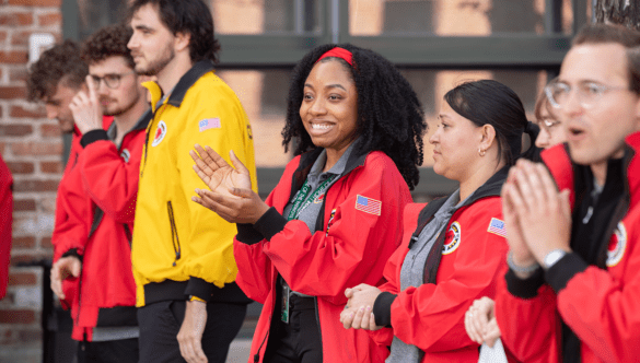 Six ɫƵ Denver AmeriCorps members clap and greet guests
